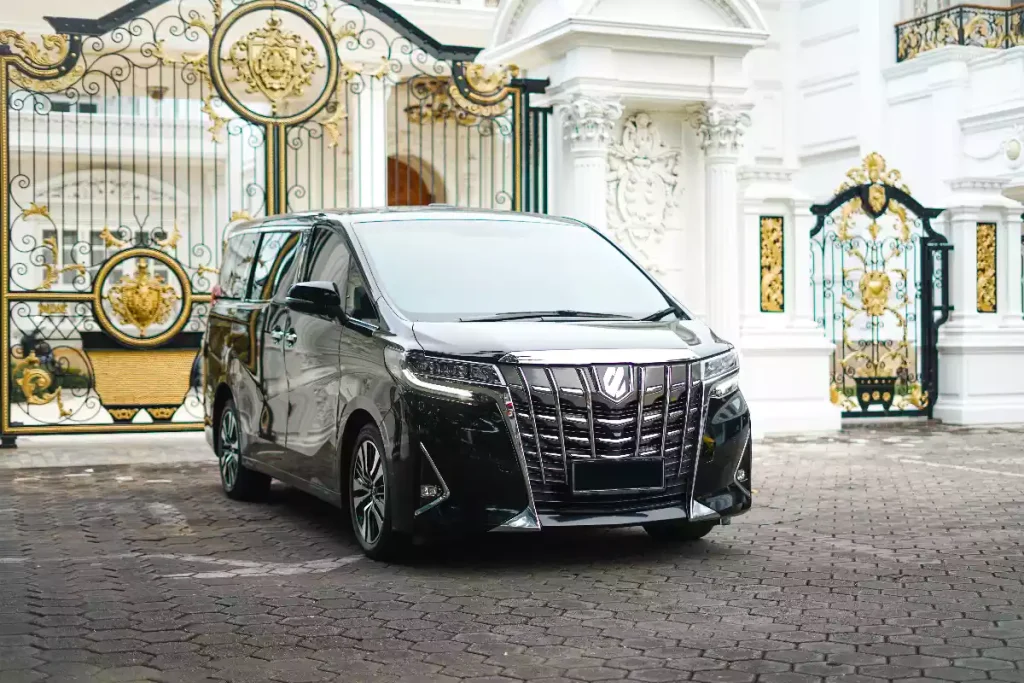 Black Toyota Alphard VIP MPV waiting at a Balinese gate