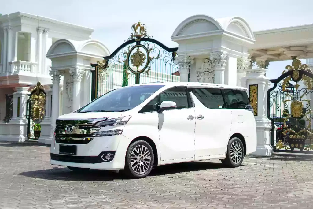 White Toyota Vellfire private tour vehicle at an ornate gate